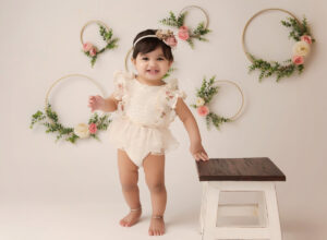 Austin Baby Photographer gitl in white outfit standing next to stool