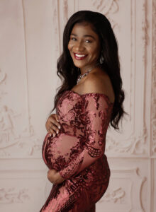 Austin Maternity Photographer expecting mom posing in formal red gown